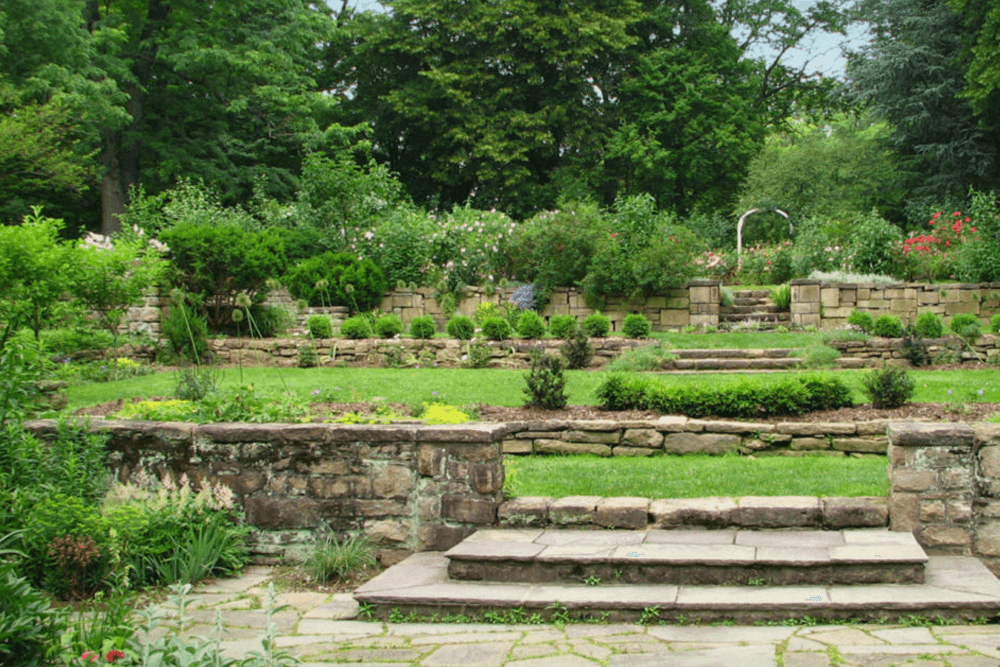 Lush garden with stone pathways and tiered flowerbeds.